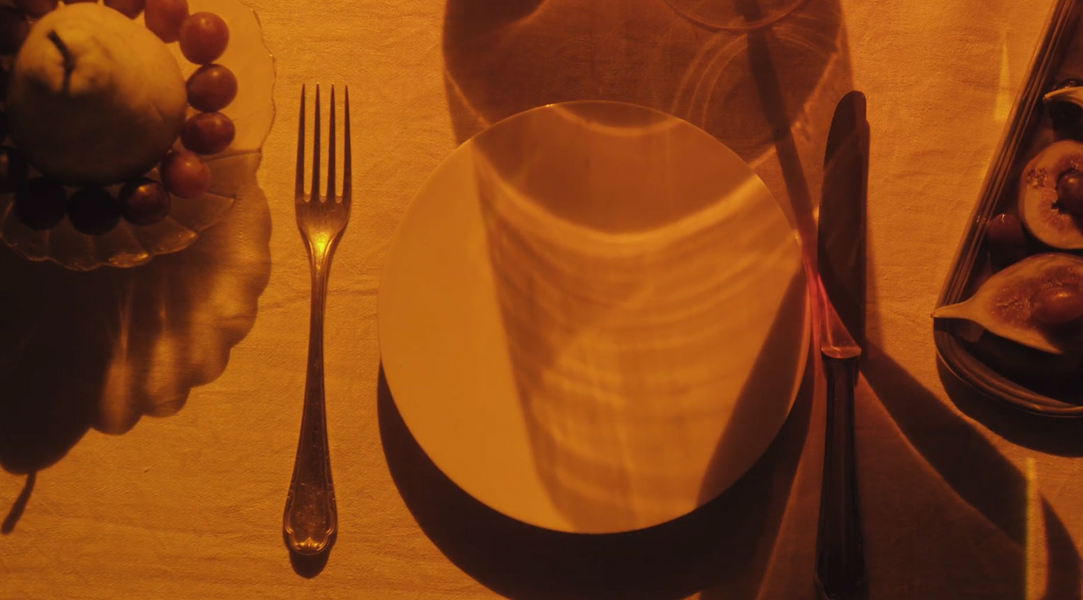 amber reflection over a place setting with a pear in the upper left